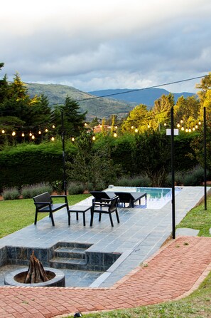 Una piscina al aire libre, sillones reclinables de piscina