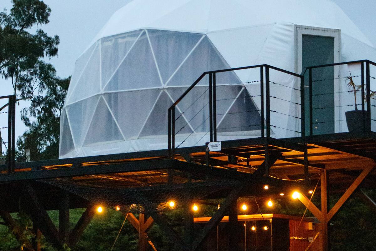 A geodesic dome structure with a viewing platform and seating area.
