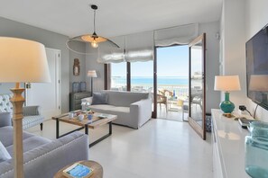 Een moderne woonkamer met een bank, salontafel en uitzicht op zee.
