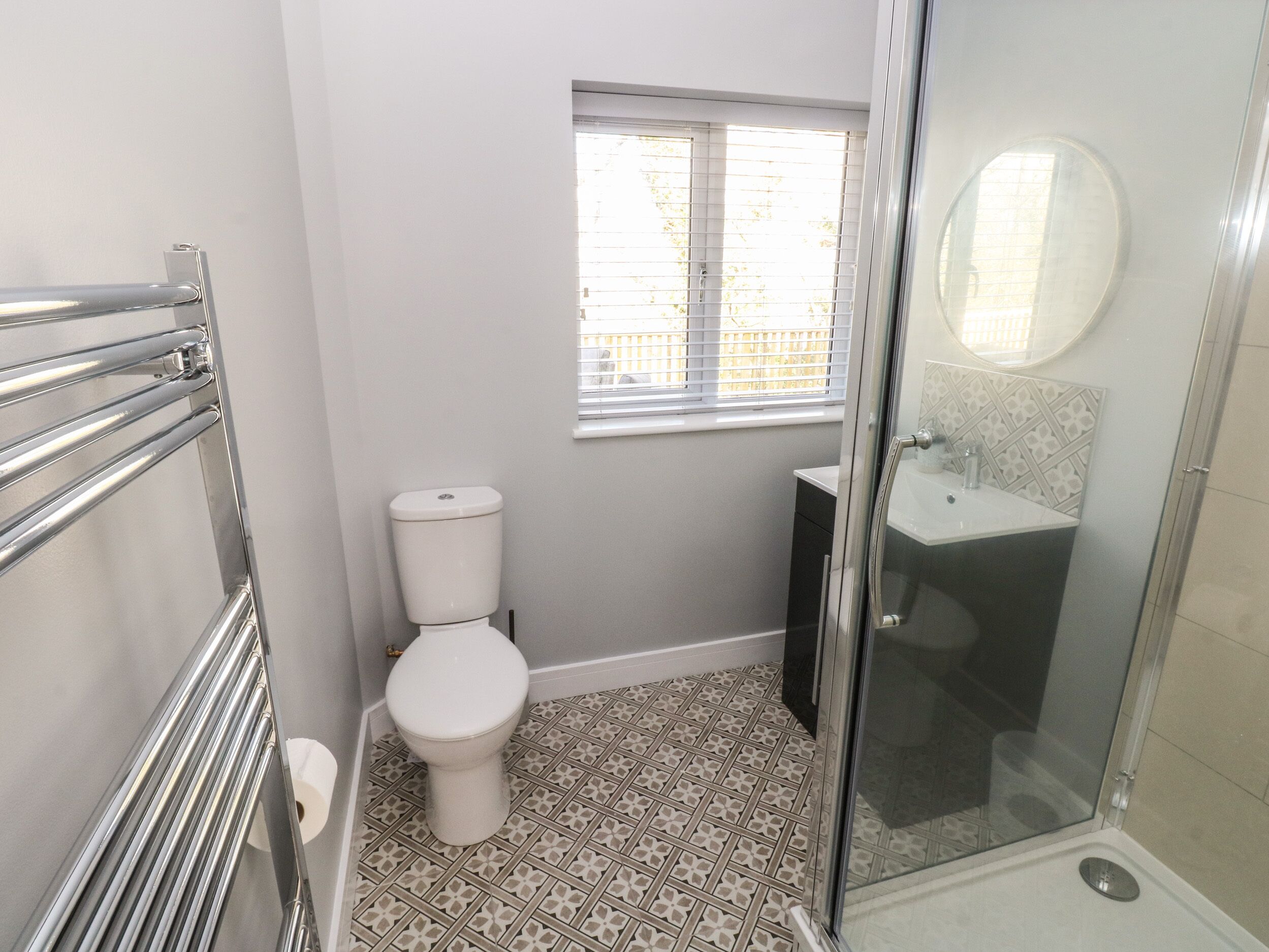 Un baño con inodoro, ducha y ventana.