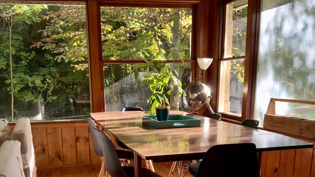 A wooden-paneled room with a large table, chairs, and a potted plant. - Spacious 3 BDR 3 BA 2 Acre property one minute from Lake Michigan-Dog Friendly! (Coloma)