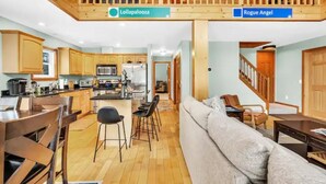 A spacious kitchen with wooden cabinets and a dining area with a table and chairs. - Sunday River 5 Min!  Family / Group / Couples Retreat! (Newry)
