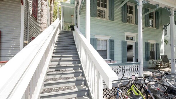 A staircase leading to a porch with a bicycle rack. - Large 1 bedroom condo in the historic area of Key West! (Key West)