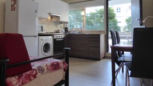Une cuisine moderne équipée d’un lave-linge, d’une cuisinière et d’un coin repas avec une table et des chaises.