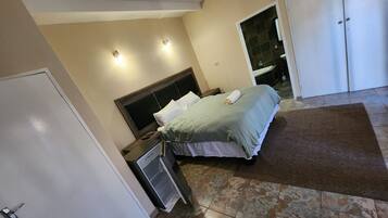 A bedroom with a bed, bedside table, and a wardrobe.