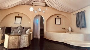 Quarto com sofá, mesa redonda e banheira.