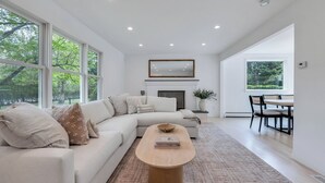 Una sala de estar moderna con un amplio sofá seccional en forma de L, una mesa de centro de madera y una chimenea.