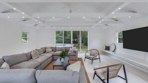 Una sala de estar moderna con un sofá modular, una mesa de centro y un televisor.
