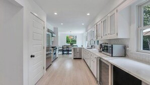 Una cocina moderna con armarios blancos, electrodomésticos de acero inoxidable y una isla central.