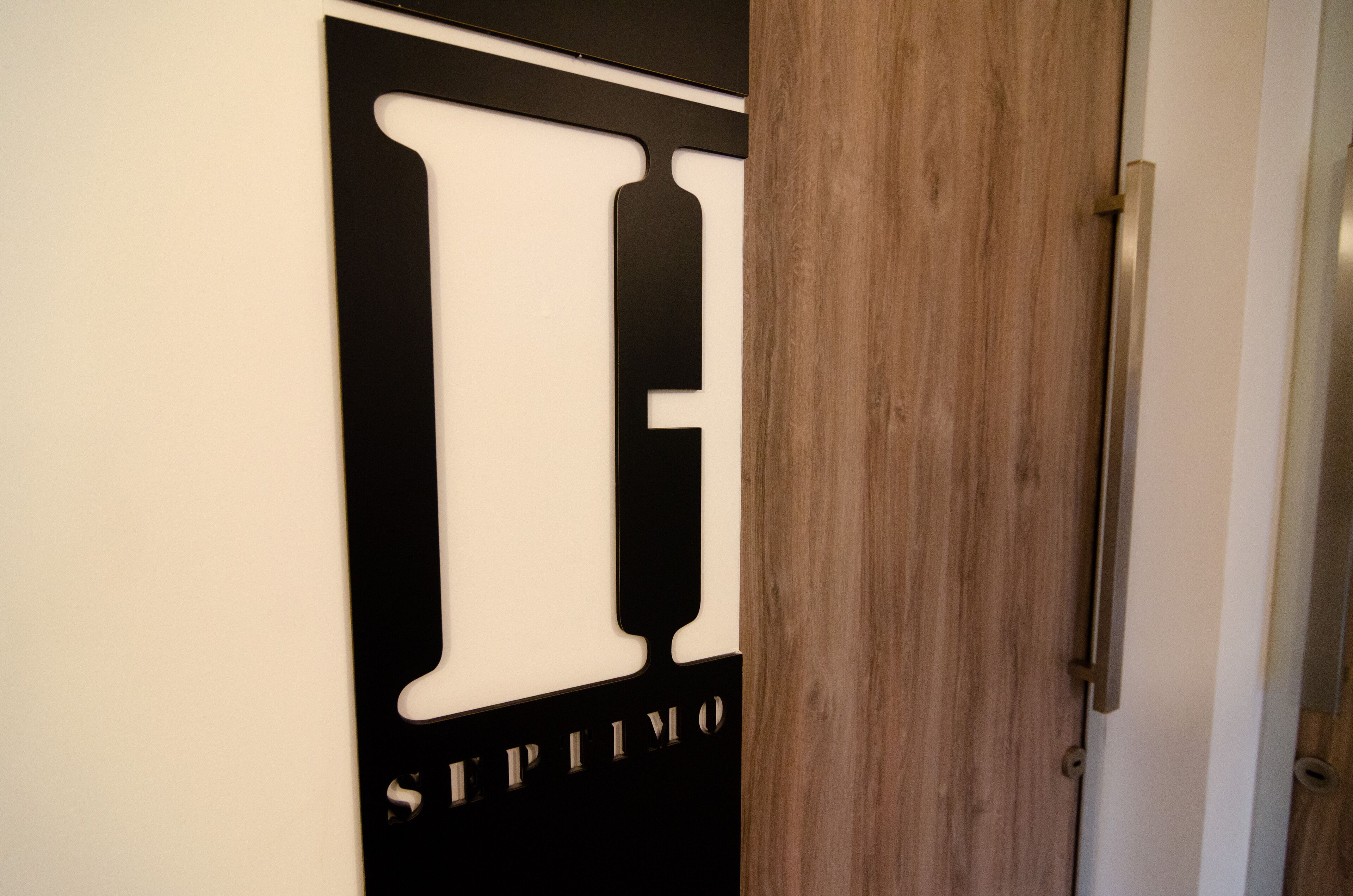 Eine Tür mit einem Schwarz-Weiß-Design, mit dem Wort "SEPTIMO" in einer fetten, modernen Schrift.