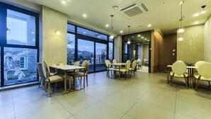 A spacious dining area with large windows, modern furniture, and a clean, well-lit interior.