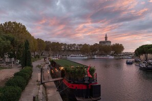 A river with boats, a bridge, and a tower in the background. - LA PENICHE Bed & Bicycle - Aigues Mortes (Aigues-Mortes)