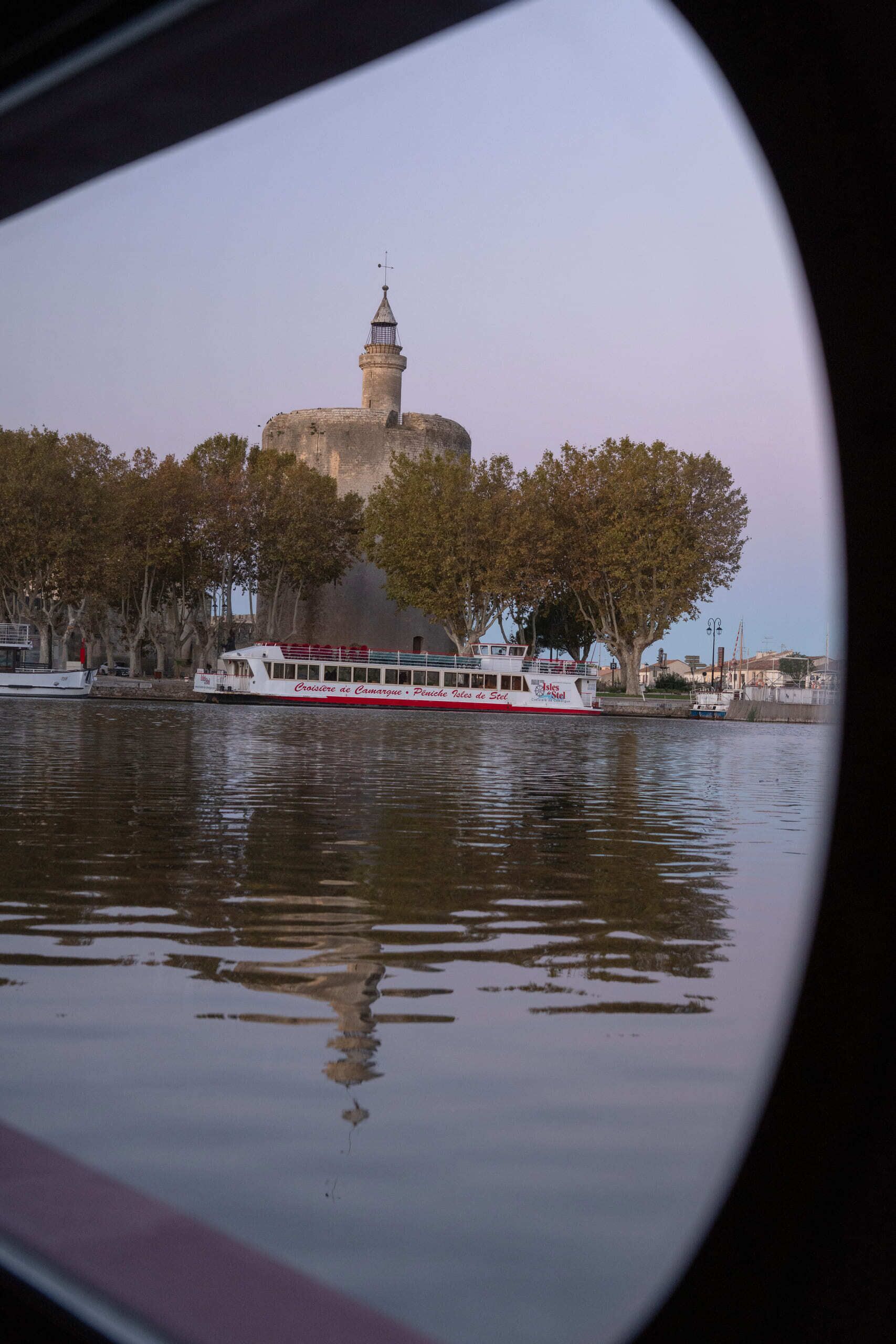 A river view with a boat and a historic building with a tower.