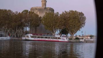 Vista sul fiume con una barca e un edificio storico con una torre.