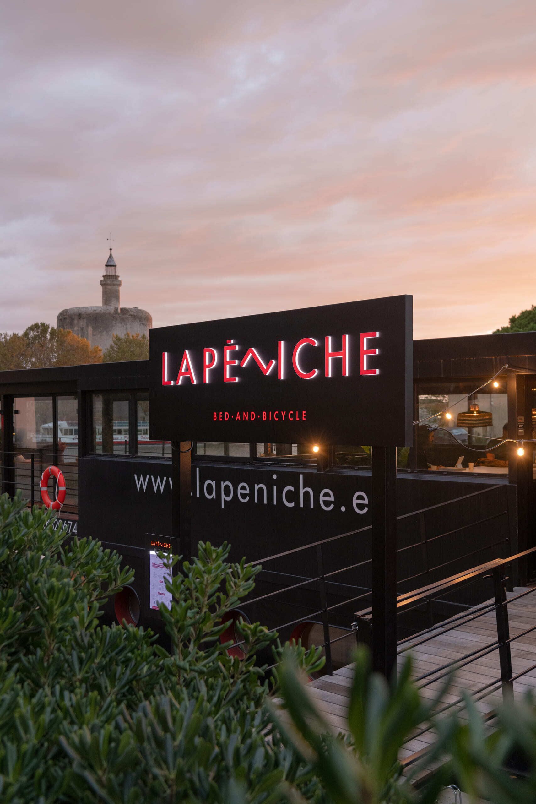 A sign for 'Lapiniche' with a website URL and a tagline 'Bed and Bicycle'.
