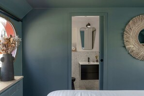 A bedroom with a bed, a dresser, a mirror, and a door leading to a bathroom. - LA PENICHE Bed & Bicycle - Aigues Mortes (Aigues-Mortes)