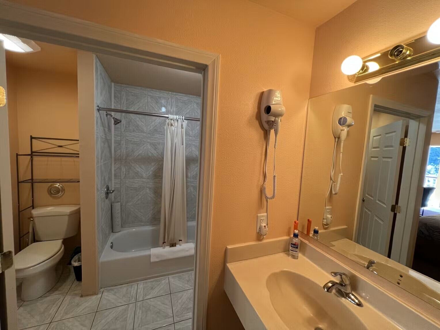 A bathroom with a shower, toilet, and sink.