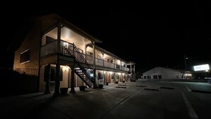 A two-story motel with a balcony on the upper floor, a staircase leading to the entrance, and a well-lit exterior. - Frazier View Motel (Frazier Park)
