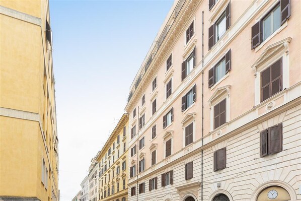 A row of classical European-style buildings with uniform facades and evenly spaced windows.