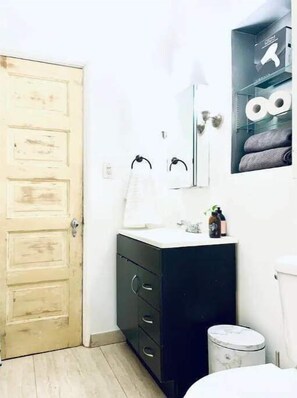 Chuveiro, secador de cabelo, toalhas de banho, sabonete