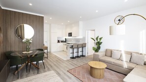 A modern living room with a glass dining table, a sofa, and a coffee table. - Skyline Lofts by LovelyStay (Matosinhos)