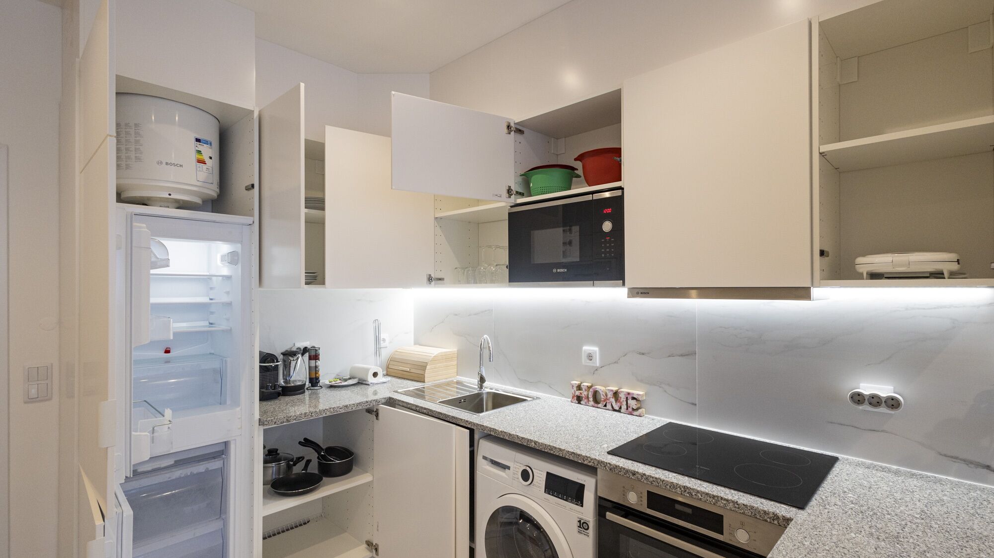 A compact kitchen with a built-in dishwasher, a microwave, and a stove.