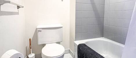 Ein modernes Badezimmer mit Toilette, Bidet und Badewanne.