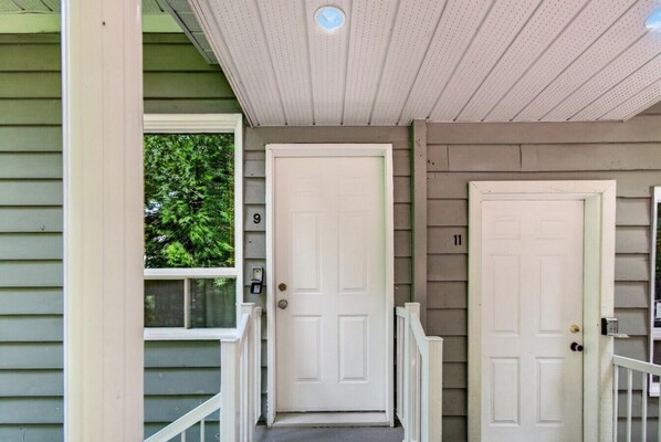 A house with a porch, a white door, and a mailbox.