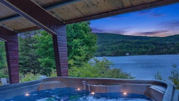 Un bain à remous avec vue sur un lac et une forêt.