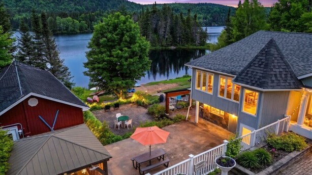 Una propiedad frente al lago con patio, mobiliario exterior y vistas al lago.