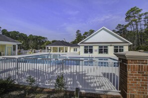 A swimming pool area with a covered pavilion, a brick wall, and a house in the background. - Beautiful home in Garden City SC golf course community with easy access to beach (Murrells Inlet)