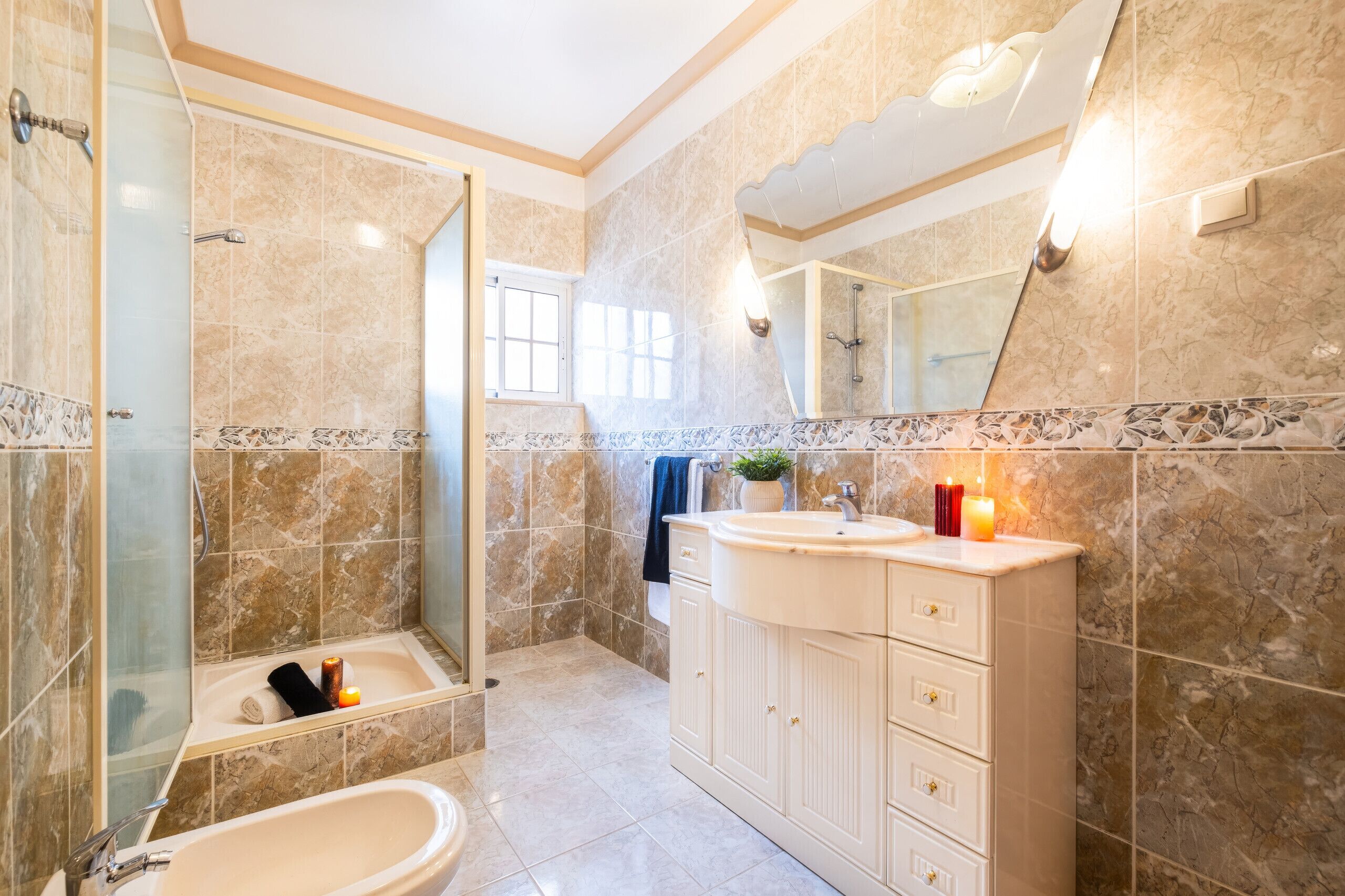 Un baño con bañera, lavamanos, espejo y ducha.