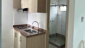 A modern kitchen with a granite countertop, stainless steel sink, and wooden cabinets.