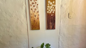 Une pièce avec une table de couleur turquoise, une plante en pot et deux tableaux accrochés au mur.