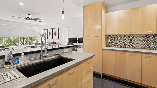 A modern kitchen with wooden cabinets, a granite countertop, and a black sink. - 2 mins 2 Mill Ave + ASU | Pool + EV Charging + GYM (Tempe)