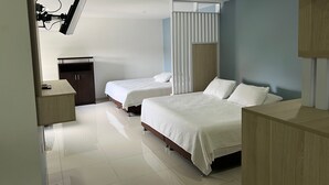 Une chambre d’hôtel moderne équipée de deux lits, d’un bureau et d’un téléviseur fixé au mur.