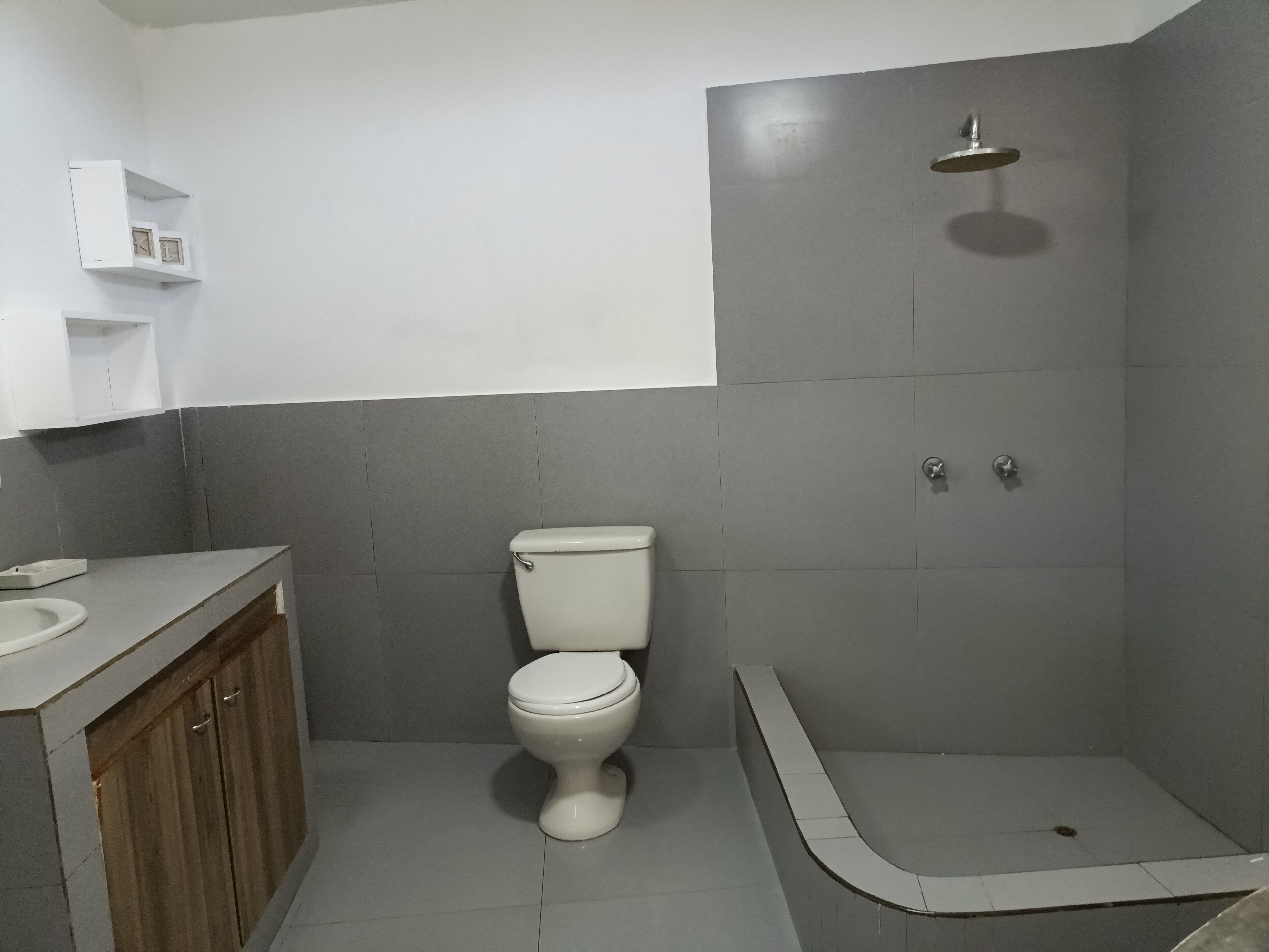 A bathroom with a toilet, a shower, and a sink.
