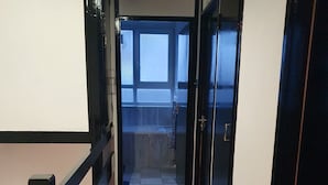 A corridor with a red carpet leading to a door with a window. - 3Beds Family Friendly in London with good transport links. Close to Victoria (London)