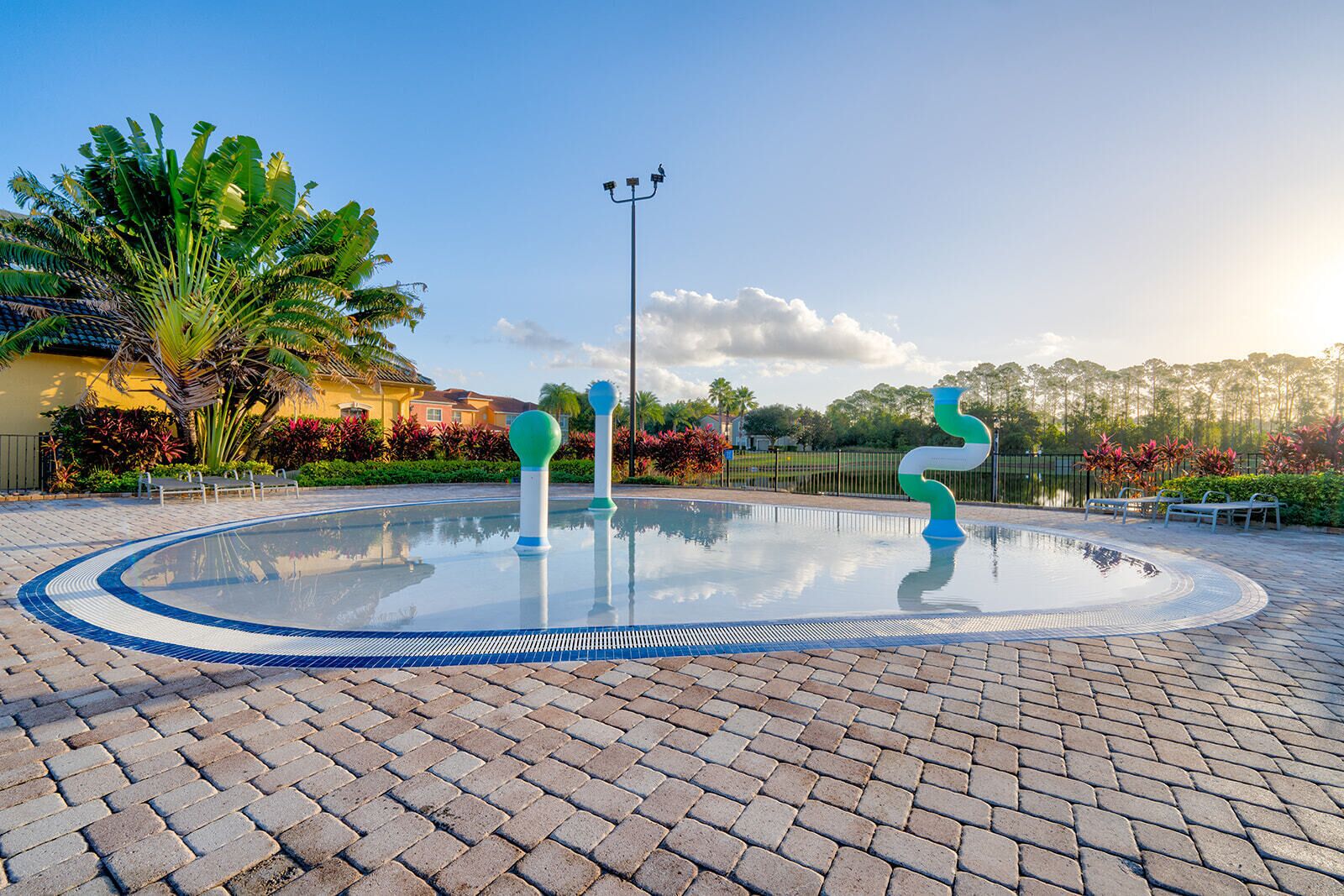 Une piscine circulaire aux bords nets, entourée d’une allée pavée.