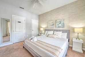 A hotel room with a large bed, two bedside tables, a ceiling fan, and a wall with two framed pictures. - !!Getaway 20 % Deal!!Beautiful Townhome with Private Pool near Disney (Kissimmee)