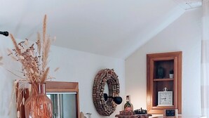 Una sala de estar acogedora con chimenea de piedra, un mueble de madera, un sofá azul y un adorno de pared.