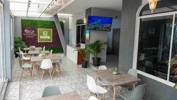 Un restaurante con una pared verde, una pantalla de televisión y un letrero que dice "PANCHA".