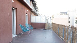 A balcony with two blue chairs, a tiled floor, and a bamboo fence. - Stylish 2 bedroom Apt in Thiseion, large balcony (Athina)