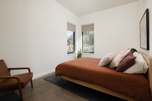 A bedroom with a bed, a chair, a window, and a plant. - Private Retreat Steps to Smith Rock | Quiet Luxury & Hot Tub (Terrebonne)