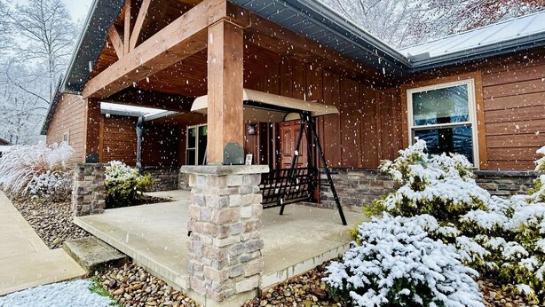 A wooden cabin with a stone foundation and a covered porch. - Quiet, country home with luxury amenities. (Dundee)