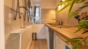 Een moderne keuken met een houten aanrecht, roestvrijstalen apparatuur en uitzicht op de eetruimte.