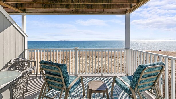 A covered outdoor seating area with a view of the beach and ocean. - One bedroom, direct ocean views! (Old Orchard Beach)