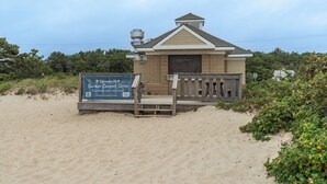 A beachside structure with a wooden deck and a sign advertising a summer concert series. - Seaside Serenity - New Construction! (Yarmouth)