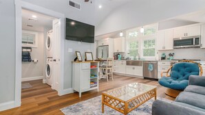 A modern kitchen with white cabinets, a stainless steel refrigerator, and a microwave. - Seaside Serenity - New Construction! (Yarmouth)