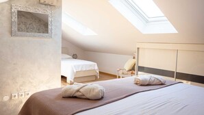 Une chambre avec un puits de lumière, un lit, une chaise et une armoire.